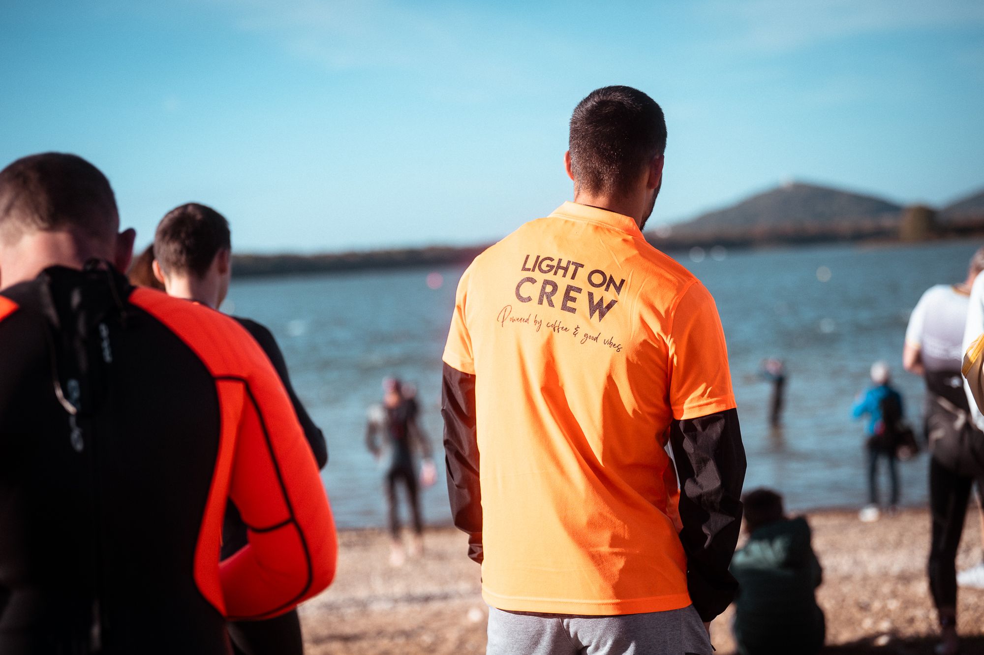 Bénévoles du LIGHT ON Crew en t-shirt orange au bord de l'eau