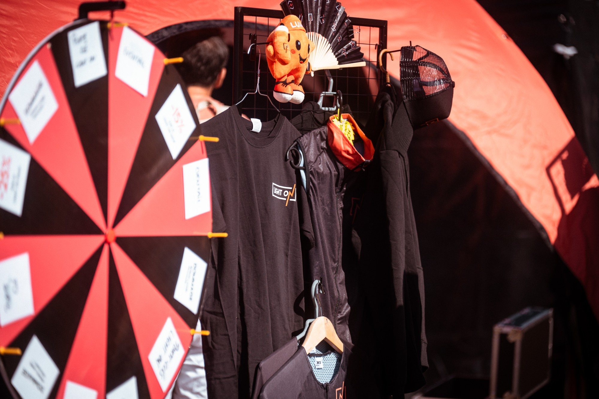 Le LIGHT ON Shop au Village LIGHT ON : roue, tee-shirts et mascotte