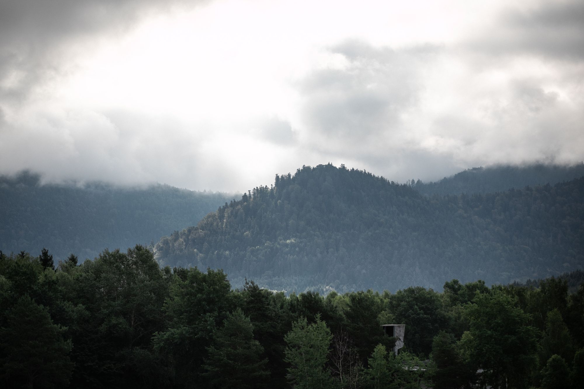 Les collines boisées autour du lac de Pierre-Percée, sous les nuages